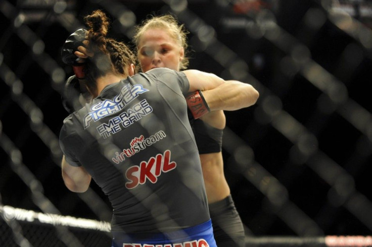 Feb 22, 2014; Las Vegas, NV, USA; Sara McMann (blue gloves) defends against Ronda Rousey (red gloves) during their UFC bantamweight championship bout at Mandalay Bay.