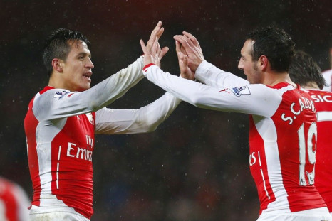 Arsenal's Alexis Sanchez (L) celebrates with team-mate Santi Cazorla after scoring a goal against Queens Park Rangers' during their English Premier League soccer match at the Emirates Stadium in London December 26, 2014.