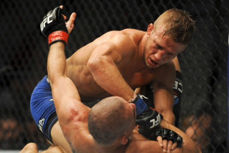 May 24, 2014; Las Vegas, NV, USA; TJ Dillashaw (blue) pins down Renan Barao (red) during their UFC 173 bantamweight championship bout at MGM Grand Garden Arena. Dillashaw won the bout by way of TKO.