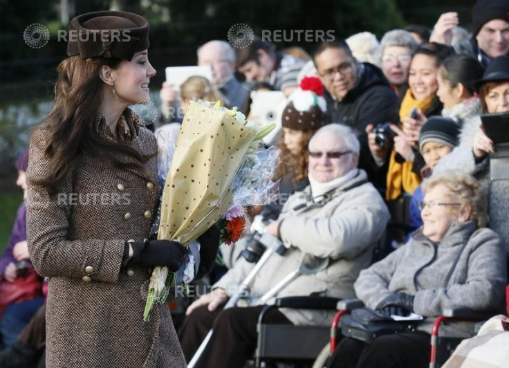 Britain's Catherine, Duchess of Cambridge carries flowers as she leaves a Christmas Day morning service 