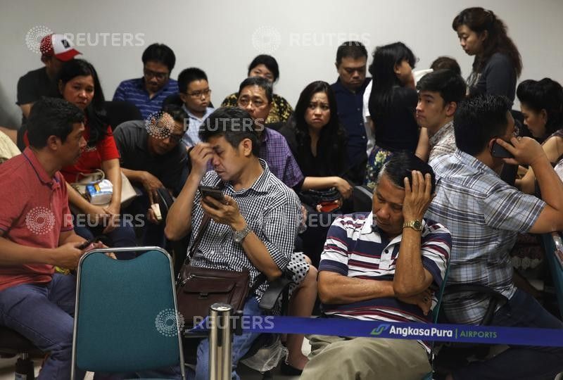 Family members of passengers onboard AirAsia flight QZ8501 react at a waiting area in Juanda International Airport