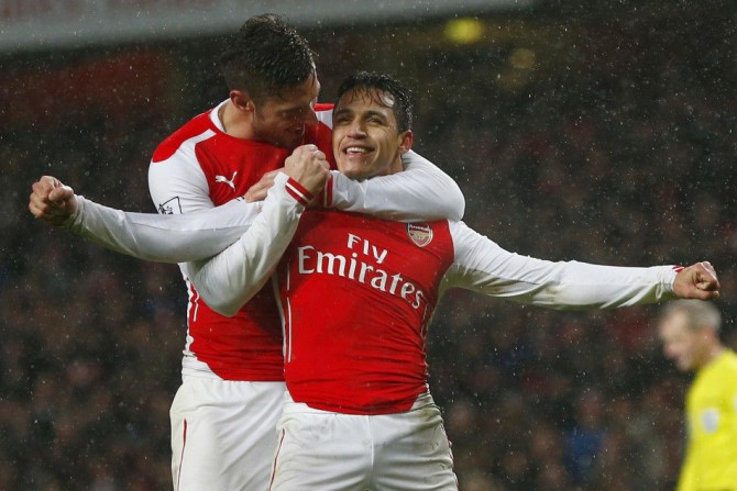 Arsenal&#039;s Alexis Sanchez (FRONT) celebrates with team-mate Olivier Giroud after scoring a goal against Queens Park Rangers during their English Premier League soccer match at the Emirates Stadium in London December 26, 2014.
