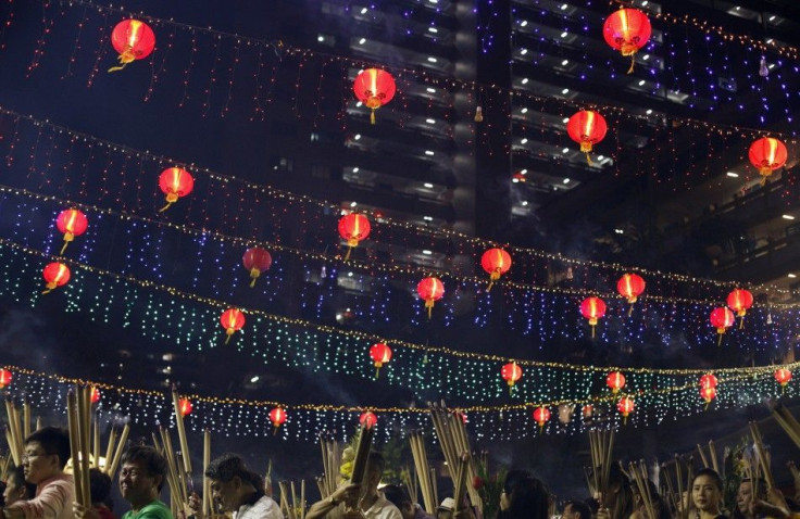 People hold up joss sticks as they wait to plant the first joss stick of the new year during Chinese New Year Eve at a temple in Singapore January 30, 2014. The Lunar New Year which welcomes the year of the horse falls on Friday.