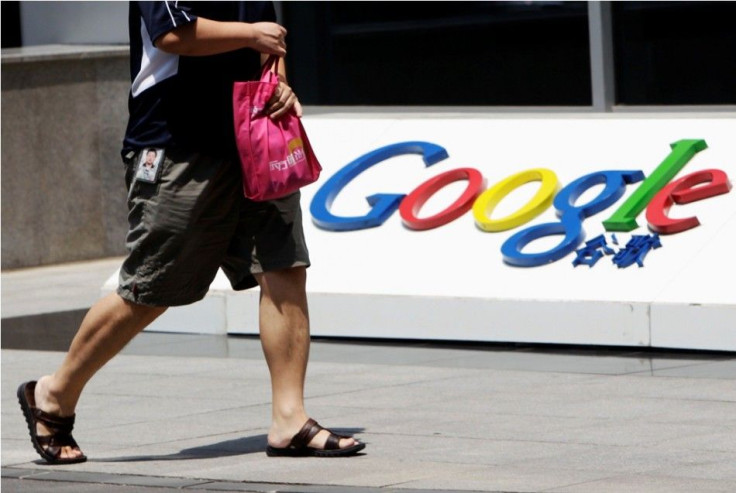 An employee walks past the logo of Google in front of its former headquarters in Beijing