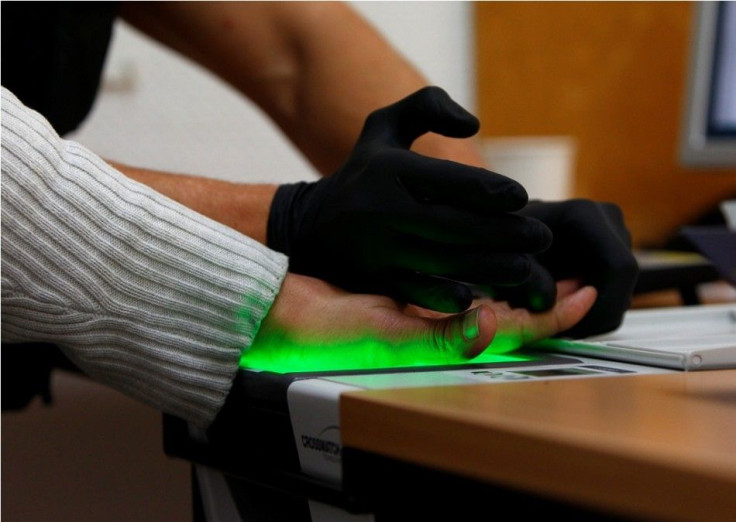 A Rosenheim federal law enforcement officer takes digital fingerprints of an illegal immigrant at a police station in Munich central railway station