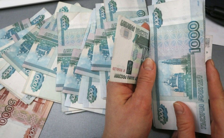 An employee counts Russian rouble banknotes
