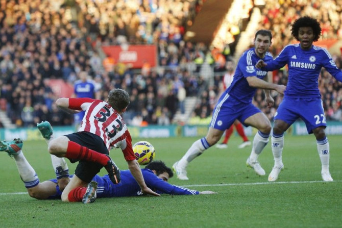 Cesc Fabregas of Chelsea is brought down by a challenge from Matt Targett (L) of Southampton in the penalty area during their English Premier League soccer match at St Mary&#039;s Stadium in Southampton, southern England December 28, 2014. Chelsea manager
