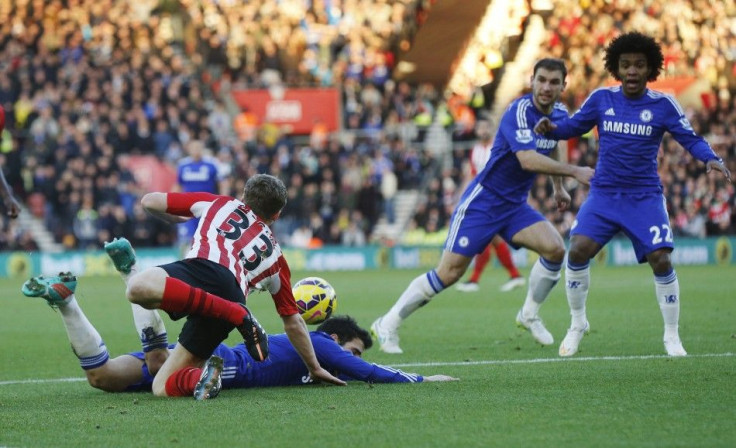 Cesc Fabregas of Chelsea is brought down by a challenge from Matt Targett (L) of Southampton in the penalty area during their English Premier League soccer match at St Mary&#039;s Stadium in Southampton, southern England December 28, 2014. Chelsea manager