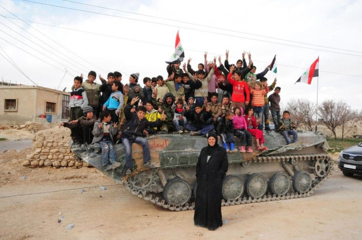 Children are seen on a troop carrier at Ras al-Ain village near Yabroud town in Damascus countryside after soldiers loyal to Syria's President Bashar al-Assad took control of it from rebel fighters, in this handout released by Syria's national news agency