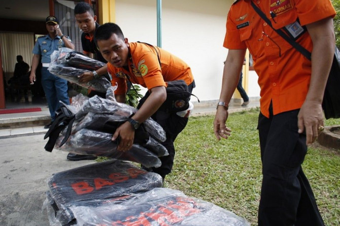 Search and rescue workers prepare to load body bags onto a flight to Kalimantan in Pangkal Pinang, Bangka December 30, 2014. Indonesian rescuers saw bodies and luggage off the coast of Borneo island on Tuesday and officials said they were &quot;95 percent