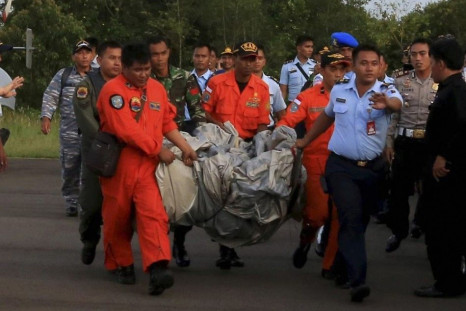 Members of the Search and Rescue Agency SARS carry debris recovered from the sea presumed from missing Indonesia AirAsia flight QZ 8501 at Pangkalan Bun, Central Kalimantan, December 30, 2014 in this photo taken by Antara Foto.