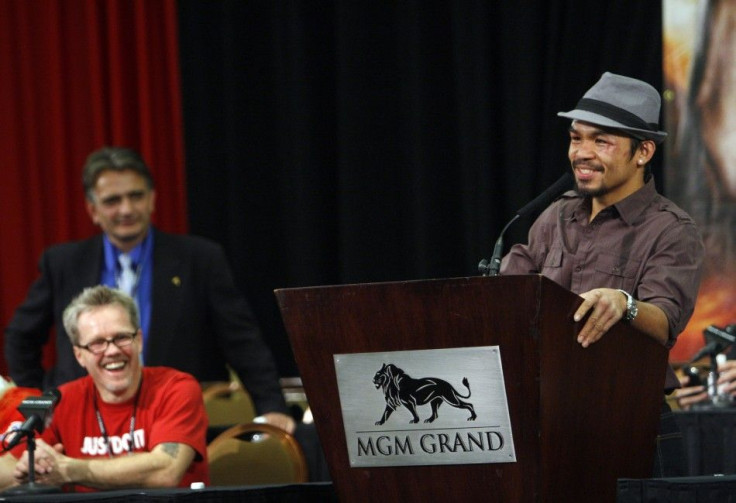 Manny Pacquiao of the Philippines speaks during a news conference following his WBO welterweight victory over Miguel Cotto of Puerto Rico at the MGM Grand Garden Arena in Las Vegas, Nevada on November 14, 2009. Listening at left are head trainer Freddie R