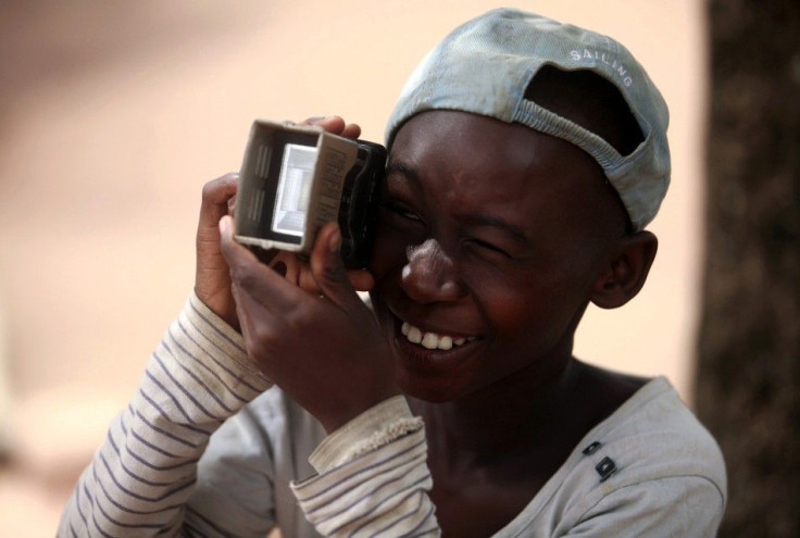 A boy gestures as he pretends to be a photographer in Soko, around 7km (4.3 miles) away from the border with Ghana July 3, 2013. REUTERS/Thierry Gouegnon