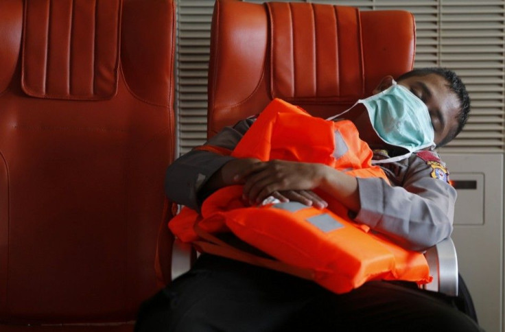 A policeman sleeps onboard the Search and Rescue (SAR) ship KN Purworejo during a search operation for passengers onboard AirAsia Flight QZ8501 in the Java Sea January 4, 2015. Bad weather forced divers trying to identify sunken wreckage from the crashed 