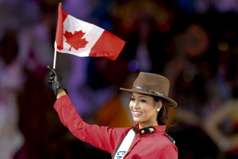 Kesiah Papasin of Canada waves a Canadian national flag as she poses in a costume similar to those used by the Royal Canadian Mounted Police during the 54th Miss International Beauty Pageant in Tokyo November 11, 2014. Women from 74 countries took part in