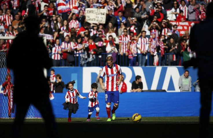 Spain forward Fernando Torres (C) runs with his children during his presentation ceremony at Vicente Calderon stadium in Madrid, January 4, 2015. Torres is returning to his beloved hometown club Atletico Madrid &quot;in pursuit of happiness&quot;, he said