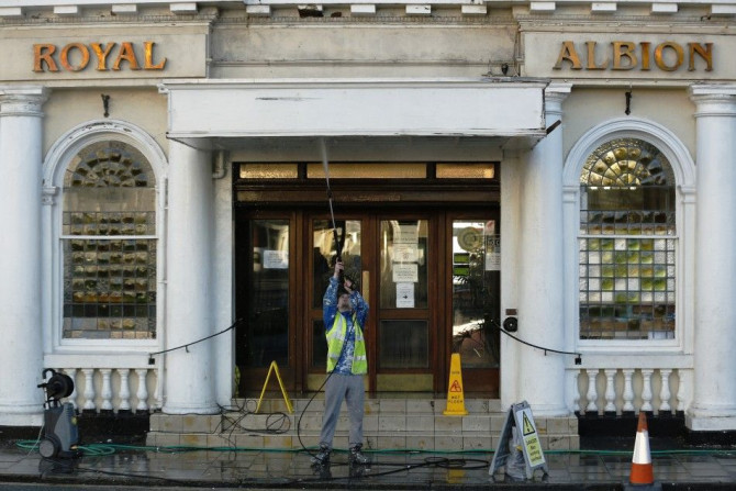 A worker hoses down the entrance to a hotel in Brighton southern England