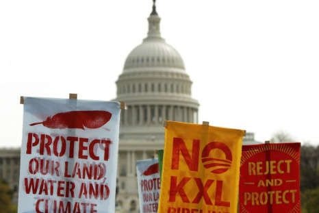 Members of the Cowboys and Indian Alliance, a group of ranchers, farmers and indigenous leaders, lift their signs in protest against the Keystone XL pipeline in front of the U.S. Capitol in Washington April 22, 2014. The latest delay to a final decision o