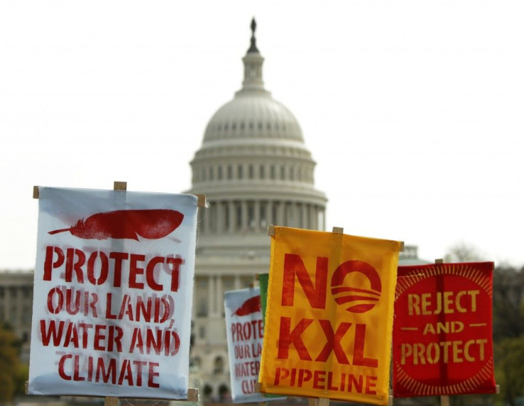 Members of the Cowboys and Indian Alliance, a group of ranchers, farmers and indigenous leaders, lift their signs in protest against the Keystone XL pipeline in front of the U.S. Capitol in Washington April 22, 2014. The latest delay to a final decision o