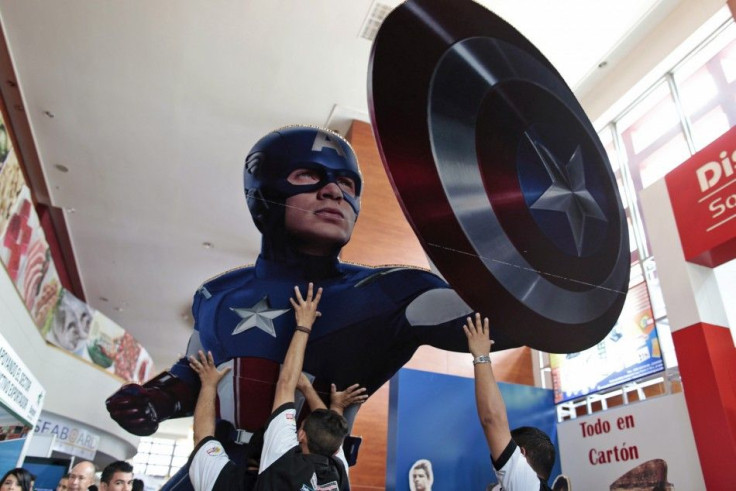 Workers set up a giant cardboard cutout of Captain America