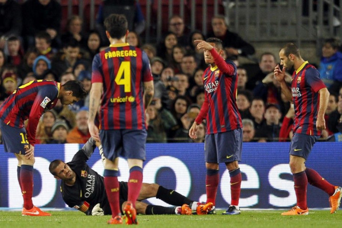 Barcelona&#039;s goalkeeper Victor Valdes (bottom), surrounded by his teammates, gestures as he lies injured on the pitch during their La Liga soccer match against Celta Vigo at Camp Nou stadium in Barcelona March 26, 2014.