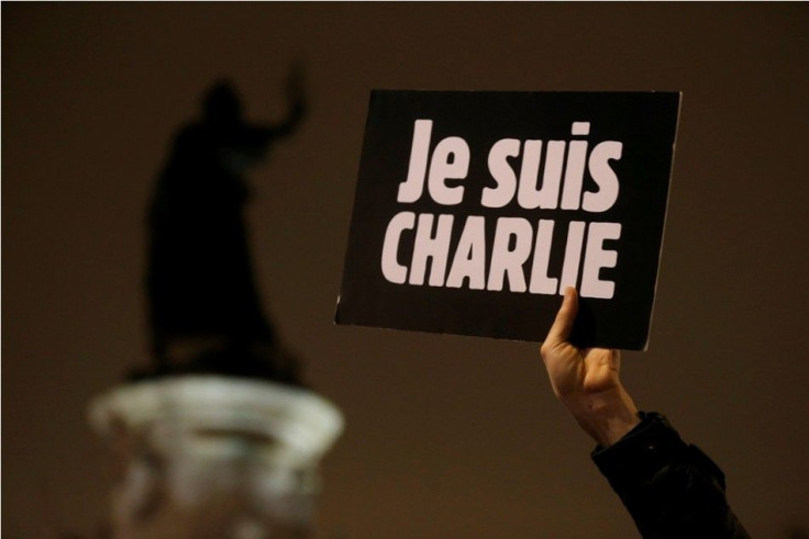 A man holds a placard which reads &quot;I am Charlie&quot; to pay tribute during a gathering at the Place de la Republique in Paris