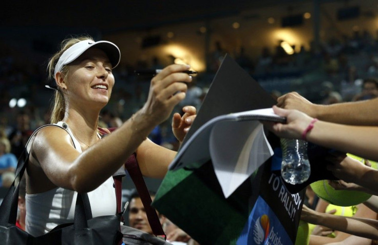 Maria Sharapova of Russia signs autographs for fans after defeating Yaroslava Shvedova of Kazakhstan in their women's singles second round match at the Brisbane International tennis tournament in Brisbane, January 6, 2015. REUTERS/Jason Reed