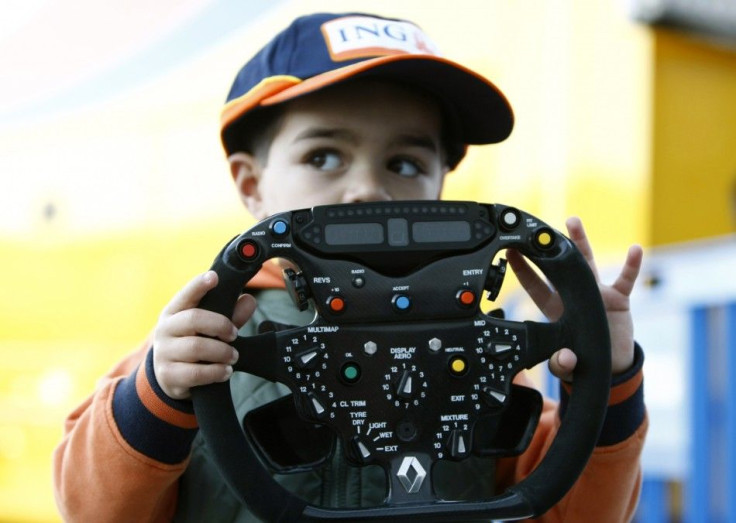 A boy holds a Renault Formula One steering wheel during a training session at the Jerez racetrack in southern Spain February 12, 2009. Motor racing chief Max Mosley has reminded Formula One drivers to race elsewhere if they are unwilling to pay for their 