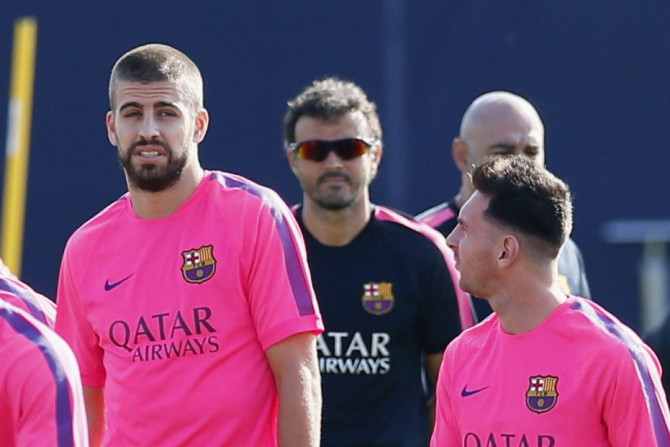 FC Barcelona&#039;s coach Luis Enrique (C) looks at his players Gerard Pique (L) and Lionel Messi (R) during a training session at Joan Gamper training camp, near Barcelona August 5, 2014.