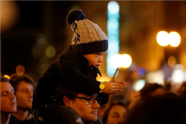 A child holds a pen during a vigil outside the Consulate General of France to pay tribute to the victims of an attack on satirical magazine Charlie Hebdo in Paris