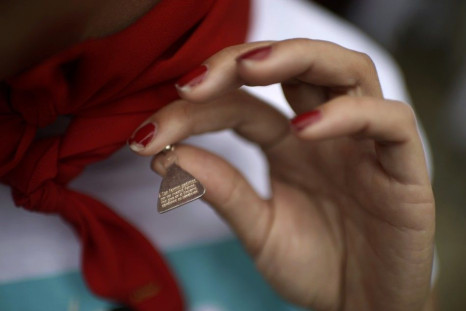Bullrunner Deirdre Carney displays an amulet asking for the protection of St Fermin following the fifth running of the bulls of the San Fermin festival in Pamplona July 11, 2014. The festival, a heady mix of drinking, dancing, late nights and bullfights, 