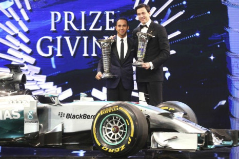 Mercedes Formula One World Champion Lewis Hamilton (L) of Britain holds his trophy next Toto Wolff, executive director of Mercedes, during the 2014 International Automobile Federation (FIA) Gala Prize-Giving ceremony in Doha December 5, 2014.