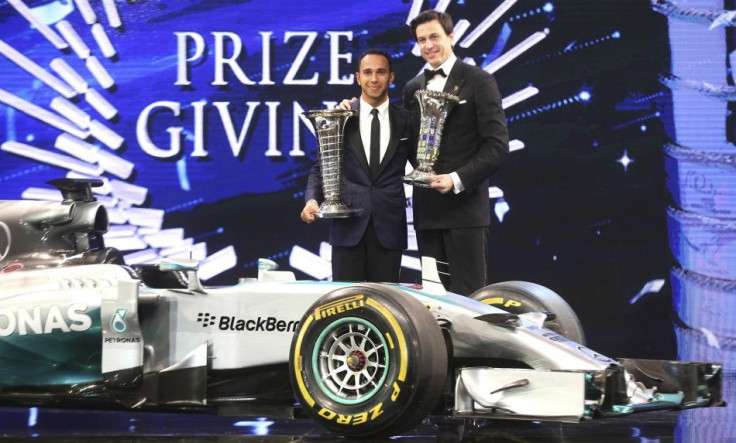 Mercedes Formula One World Champion Lewis Hamilton (L) of Britain holds his trophy next Toto Wolff, executive director of Mercedes, during the 2014 International Automobile Federation (FIA) Gala Prize-Giving ceremony in Doha December 5, 2014.