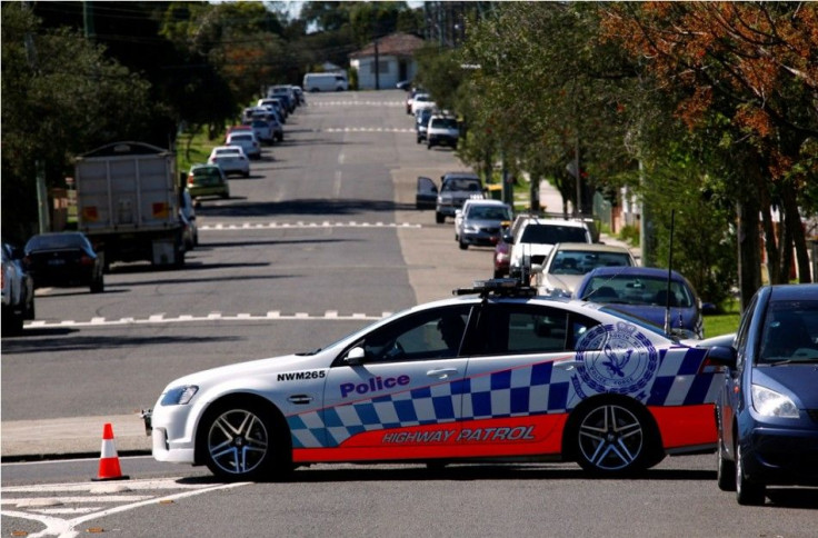 A policeman sits in his patrol car as part of a road block on the street