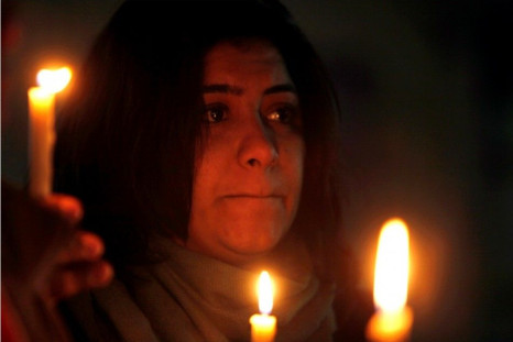 A woman holds candles during a candlelight vigil for the victims