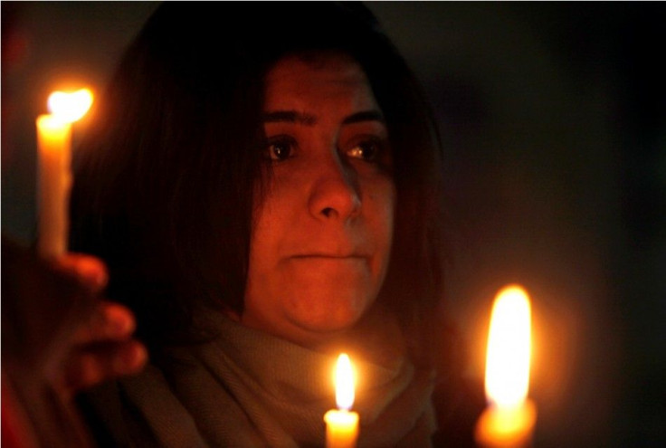 A woman holds candles during a candlelight vigil for the victims