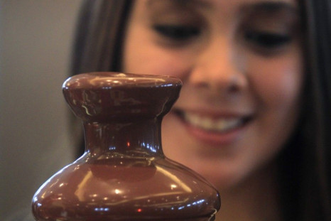A hostess serves visitors at a chocolate fountain during a chocolate convention in Lima July 7, 2011. The three-day exhibition, which drew distributors from Latin America and chocolate sommeliers from Europe, featured organic dark chocolate candy bars, ch