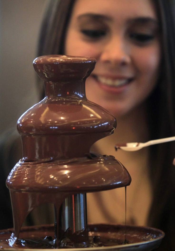 A hostess serves visitors at a chocolate fountain during a chocolate convention in Lima July 7, 2011. The three-day exhibition, which drew distributors from Latin America and chocolate sommeliers from Europe, featured organic dark chocolate candy bars, ch