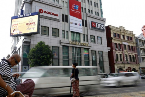 Traffic travels past signs of OCBC and DBS banks at Sakura tower in Yangon October 3, 2014. Myanmar has thrown open the door to foreign banks, but weak credit protection and tight restrictions on lending mean it's not a warm welcome, at least not yet. To 