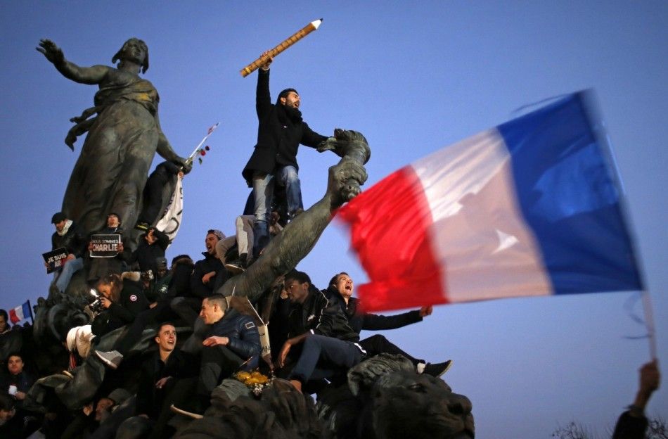 A man holds a giant pencil as he takes part in a Hundreds of thousands of French citizens solidarity march Marche Republicaine in the streets of Paris January 11, 2015. French citizens will be joined by dozens of foreign leaders, among them Arab and Mus