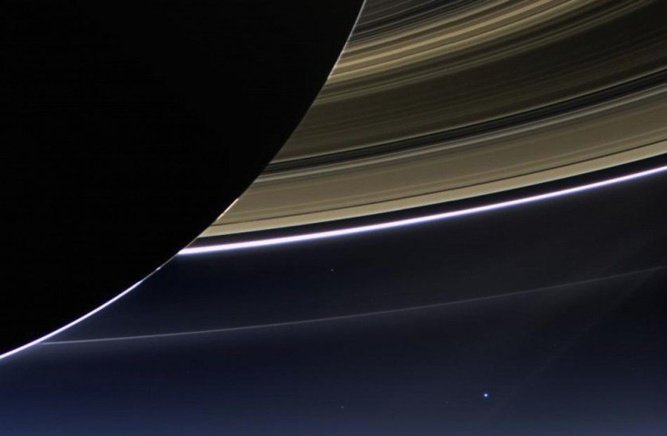 Saturn&#039;s rings and our planet Earth and its moon are seen in this image taken by the wide-angle camera on NASA&#039;s Cassini spacecraft July 19, 2013. Earth, which is 898 million miles (1.44 billion km) away in this image, appears as a blue dot at c