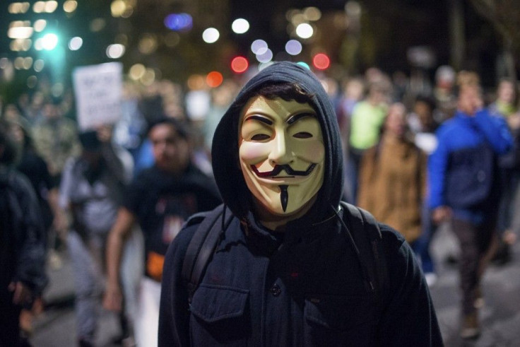 A protester wears a Guy Fawkes mask while marching with more than 100 demonstrators against police violence in Berkeley, California December 10, 2014. REUTERS/Noah Berger