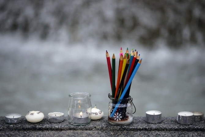 Pencils, representing the freedom of expression, are seen near candles as several thousand people gather to pay tribute to the victims following a shooting on Wednesday by gunmen at the offices of the satirical weekly newspaper Charlie Hebdo during a demo