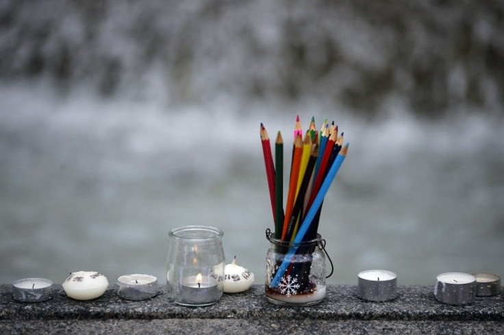 Pencils, representing the freedom of expression, are seen near candles as several thousand people gather to pay tribute to the victims following a shooting on Wednesday by gunmen at the offices of the satirical weekly newspaper Charlie Hebdo during a demo