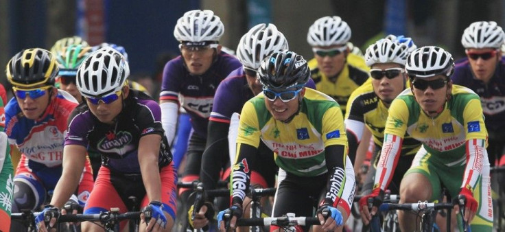 Cyclists ride around Hoan Kiem lake during a trans-Vietnam cycling tournament in Hanoi December 13, 2014. As many as 300 riders representing 15 domestic and two foreign teams (Laos and Cambodia) are participating in a trans-Vietnam cycling tournament from