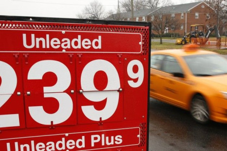 A taxi passes a gas station in Falls Church, Virginia December 16, 2014. For the first time in more than a decade, U.S. gasoline prices are tumbling toward $2 a gallon even as the economy grows and unemployment shrinks, a constellation that will test the 