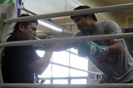Filipino world boxing champion Manny Pacquiao lands a punch on his conditioning coach Alex Ariza as he joked him before the start of his training in northern Philippine resort city of Baguio March 23, 2011. Pacquiao is in Baguio on a month-long training p