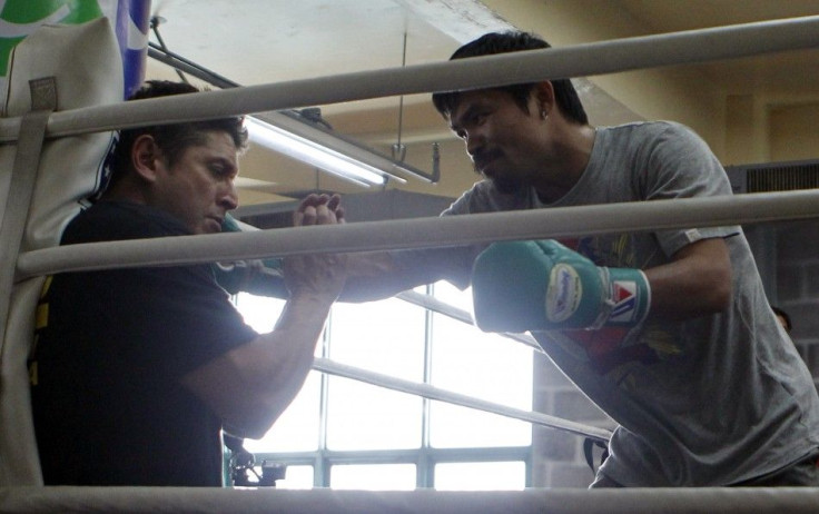 Filipino world boxing champion Manny Pacquiao lands a punch on his conditioning coach Alex Ariza as he joked him before the start of his training in northern Philippine resort city of Baguio March 23, 2011. Pacquiao is in Baguio on a month-long training p