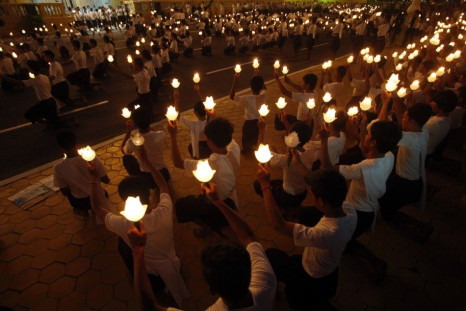 People hold up torches in front of the Royal Palace during a ceremony in Phnom Penh July 10, 2014. A three-day royal procession to take the remains of late Cambodian King Norodom Sihanouk from the cremation site to the Royal Palace began on Thursday.