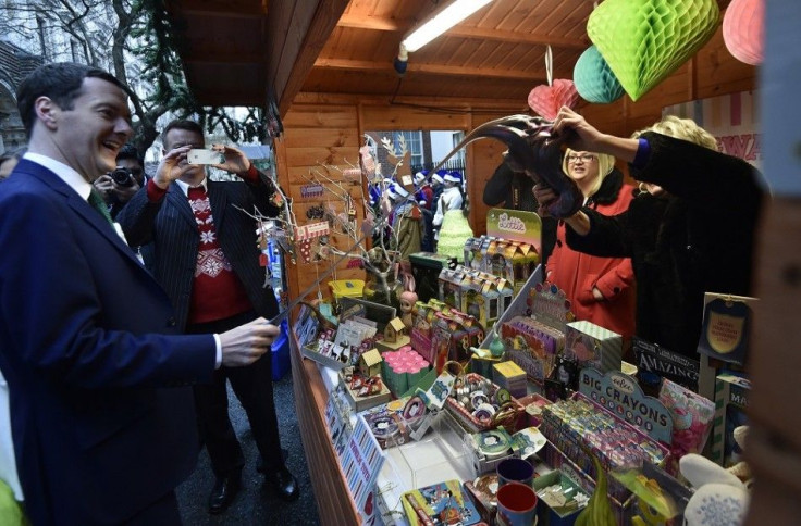 Britain's Chancellor of the Exchequer George Osborne (L) examines a children's toy at market stalls promoting the livelihoods of small business owners at Downing Street in London, December 5, 2014.